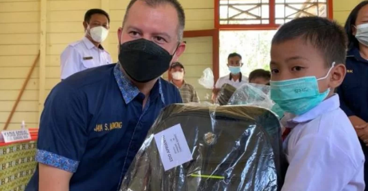 Bupati Gumas Jaya S Monong didampingi Kepala Dinsos Gumas Jhonson Ahmad saat menyalurkan bantuan paket peralatan sekolah kepada seorang peserta didik di Kelurahan Tumbang Marikoi Kecamatan Damang Batu, Rabu (17/11/2021). (Foto : Diskominfosantik Gumas)