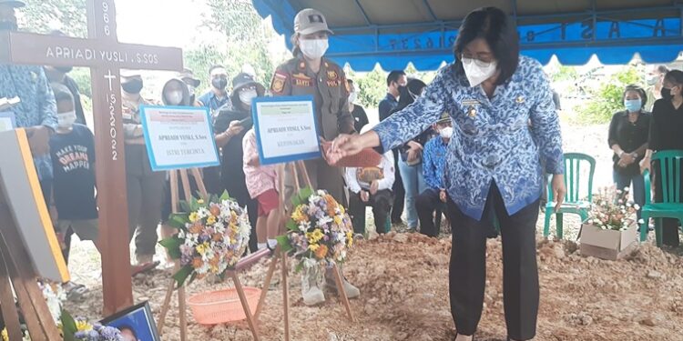 Wabup Efrensia L.P Umbing menabur bunga di makam almarhum Kasubbag Umum dan Kepegawaian Satpol PP Gumas Apriadi Yusli, di Tempat Pemakaman Umum Jalan Adonis Samad Kuala Kurun, Kamis (17/2/2022). (MASAPNEWS/GCM)