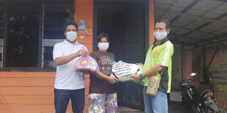 Plt Ketua Dusmala Kabupaten Gumas Heppy Kariano (kiri) dan Bendahara Dusmala Kabupaten Gumas Yono (kanan) saat menyalurkan bingkisan kasih Natal kepada warga di Kuala Kurun, Kecamatan Kurun, Jumat (19/2/2022). (MASAPNEWS/GCM)