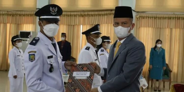 Bupati Gumas Jaya S Monong menyerahkan SK kepada salah satu kades terpilih hasil Pemilihan Kepala Desa Serentak Gelombang III tahun 2021, di GPU Damang Batu Kuala Kurun, Kamis (10/3/2022). (Foto : Protokol dan Perjalanan Setda Gumas)