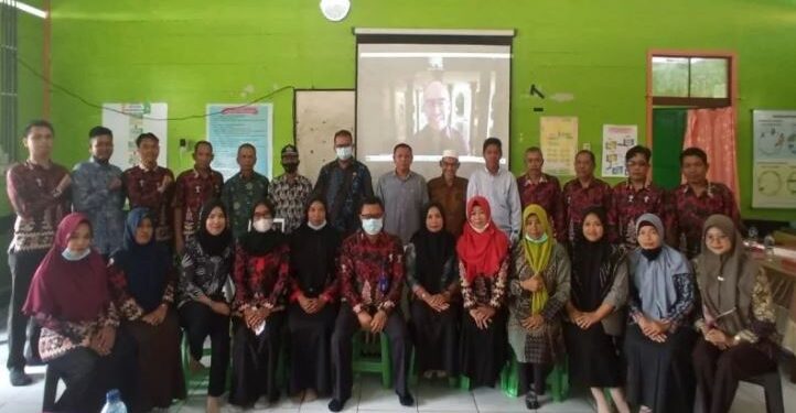 Wakil Ketua DPRD Kotawaringin Timur Rudianur (tengah kemeja abu-abu) bersama guru SMPN 1 Mentaya Hilir Selatan mendengarkan pernyataan Rusdi Akbar (layar video) yang menghibahkan tanahnya untuk pembangunan SMPN 1 Samuda, Sabtu (19/3/2022). (ANT/IST)