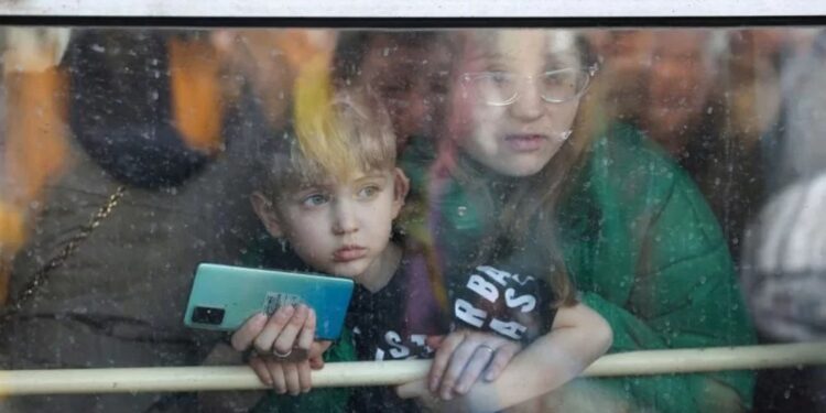 Seorang warga beserta anaknya menatap keluar kereta yang ditumpanginya saat evakuasi warga di stasiun Kyiv, Ukraina, Jumat (25/2/2022). Evakuasi warga terus berlanjut seiring pecahnya perang akibat operasi militer Rusia di Ukraina. (MASAPNEWS/ANT/REUTERS)