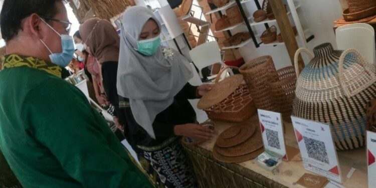 Nurmalalia Hidayati (kanan) pemilik Bale Rattan Lombok ketika memamerkan produk kerajinan anyaman rotan kepada salah seorang pengunjung dalam kegiatan Karya Kreatif Indonesia di Kawasan Ekonomi Khusus (KEK) Mandalika, NTB, Rabu (3/3/2021). (MASAPNEWS/ANT)