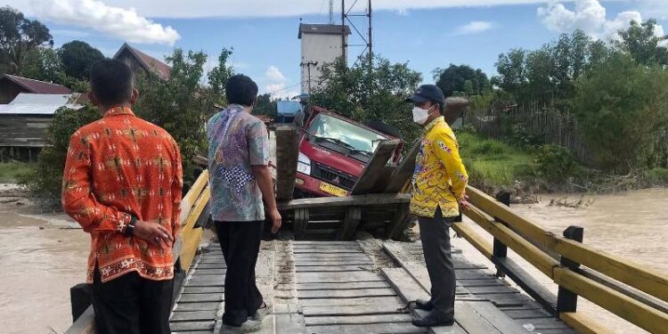 Kepala DPU Kabupaten Gumas Baryen (kanan) saat meninjau Jembatan Sei Rawi I yang ambruk, Kamis (24/3/2022). (Foto : Facebook @Dinas Pekerjaan Umum)