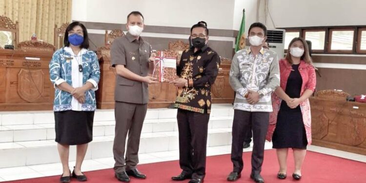 Bupati Gumas Jaya S Monong menyerahkan draft raperda ke Ketua DPRD Gumas Akerman Sahidar, saat rapat paripurna di ruang rapat paripurna DPRD setempat, Jumat (11/3/2022). (Foto : Diskominfosantik Gumas)