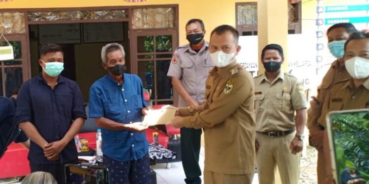 Bupati Gumas Jaya S Monong menyalurkan bantuan dana kepada warga yang terkena musibah kebakaran rumah, di Desa Penda Pilang Kecamatan Kurun, Selasa (22/2/2022). (Foto : BPBD Kabupaten Gumas)