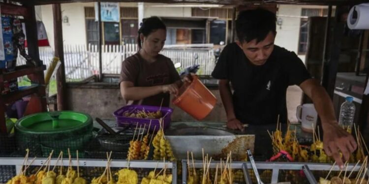 Pedagang menyiapkan makanan gorengan pada lapak dagangannya di Jalan Sisingamangaraja, Palangkaraya, Kalimantan Tengah, Sabtu (2/4/2022). (MASAPNEWS/ANT)