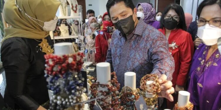 Menteri BUMN Erick Thohir (tengah) mengamati produk UMKM usai menghadiri acara "Erick Thohir Menyapa Srikandi BUMN" di Jakarta, Kamis (21/4/2022). (MASAPNEWS/ANT)