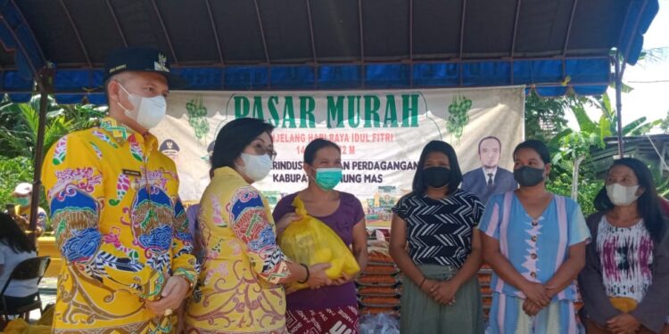 Bupati Gumas Jaya S Monong dan Wakil Bupati Efrensia LP Umbing menyalurkan paket bahan pokok secara simbolis, saat pelaksanaan operasi pasar murah di Desa Tampelas Kecamatan Sepang, Kamis (28/4/2022). (Foto : Disperindag Gumas)