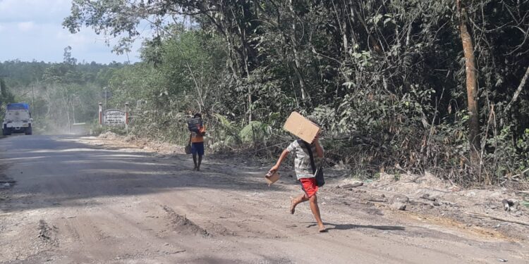 Anak-anak dibawah umur ini sedang menunggu pemberian dari supir truk dan kendaraan umum yang sedang melintas. (fhoto: Heriyadi)