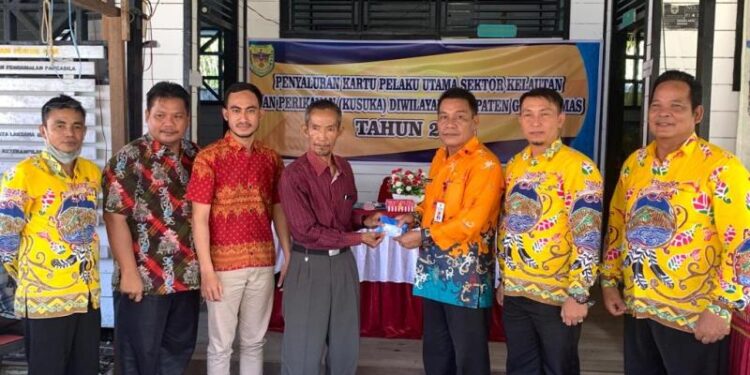Kepala DPKP Kabupaten Gumas Hansli Gonak (ketiga dari kanan) menyalurkan Kusuka kepada pelaku usaha perikanan di Desa Sepang Kota, Kecamatan Sepang, baru-baru ini. (Foto : DPKP Kabupaten Gumas)