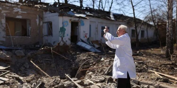 Dokter Anatolii Pavlov mengambil gambar rumah sakit jiwa yang rusak akibat terkena serangan militer Rusia ke Ukraina di Mykolaiv, Ukraina, Selasa (22/3/2022). (MASAPNEWS/ANT/REUTERS)