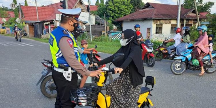 Anggota Satlantas Polres Gumas mengimbau pengguna sepeda listrik yang tidak menggunakan helm agar menggunakan helm saat melintas di jalan umum di Kota Kuala Kurun, awal Juni 2022. (IST)