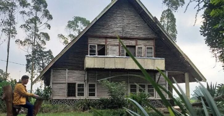 Seorang pengunjung yang sedang duduk di depan objek wisata horor, Rumah Pengabdi Setan yang terletak di lahan milik PTPN VIII, tepatnya di Kampung Kertamanah, Desa Margamukti, Kecamatan Pangalengan, Kabupaten Bandung, Jawa Barat. (ANT/Ajat Sudrajat/am.)