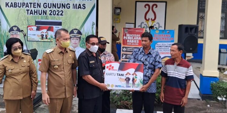 Ketua DPRD Kabupaten Gunung Mas Akerman Sahidar didampingi Bupati Jaya S Monong, Wakil Bupati Efrensia LP Umbing, menyerahkan Kartu Tani secara simbolis kepada petani, di Kuala Kurun, Senin (20/6/2022). (MASAPNEWS/GCM)