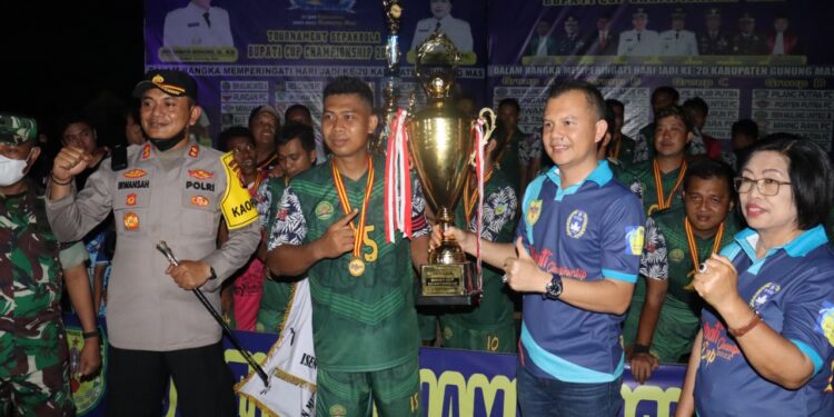 Bupati Gumas Jaya S Monong didampingi Wakil Bupati Efrensia LP Umbing dan Kalpores AKBP Irwansah saat menyerahkan tropy kepada Tim Isen Mulang United A usai partai final di Lapangan Isen Mulang Kuala Kurun, Senin (20/6/2022). (Foto : Diskominfosanti Kabupaten Gumas)