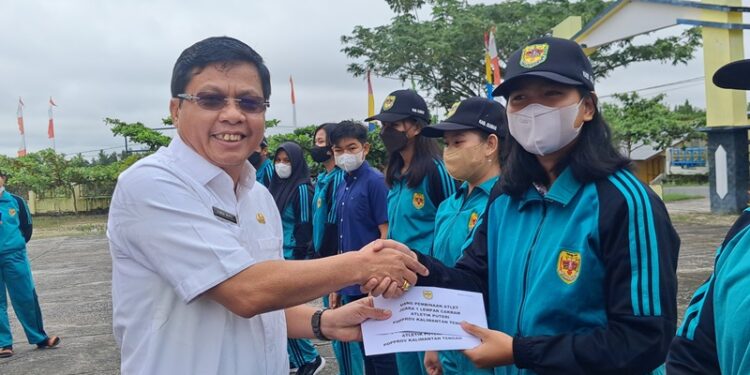 Kepala Disdikpora Kabupaten Gumas Esra menyerahkan bonus kepada Gresia Nataka, di kantor Disdikpora setempat, Rabu (13/7/2022). (MASAPNEWS/GCM)