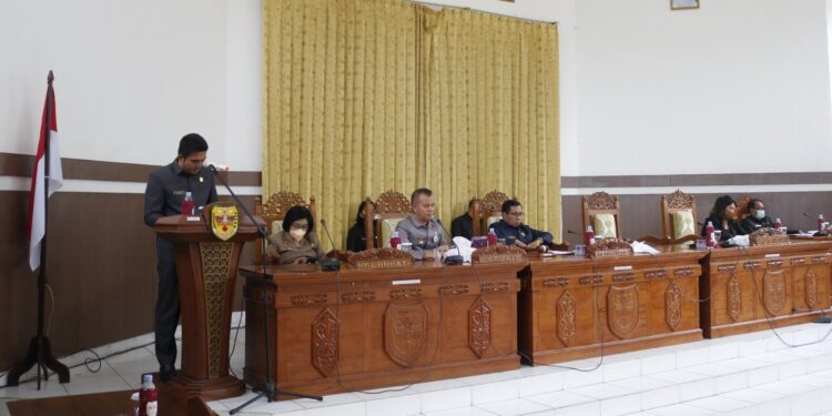 Wakil Ketua Badan Anggaran DPRD Kabupaten Gumas Binartha saat menyampaikan laporan hasil pembahasan Raperda Pertanggungjawaban pelaksanaan APBD tahun 2021, serta rancangan KUA-PPAS tahun anggaran 2023, pada Rapat Paripurna ke-4 Masa Persidangan III Tahun Sidang 2022, Rabu (13/7/2022). (Foto : Protokol dan Perjalanan Setda Gumas)