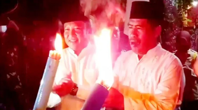 Wakil Ketua Komisi III DPRD Kotim Dadang Siswanto (kiri) bersama rekannya sesama legislator Rambat saat membuka pawai obor memeriahkan malam Hari Raya Idul Adha 1443 Hijriah di Kecamatan Baamang, Sabtu (9/7/2022) malam. (ANT)