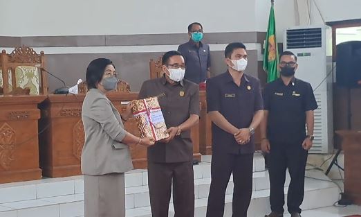 Wabup Gumas Efrensia L.P Umbing menyerahkan Raperda dan Rancangan KUA PPAS kepada Ketua DPRD Gumas Akerman Sahidar saat rapat paripurna di Kuala Kurun, Senin (4/7/2022). (MASAPNEWS/GCM)