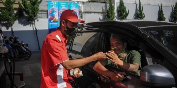 Dokumentasi. Petugas SPBU memberikan panduan kepada seorang pengendara untuk pengisian BBM melalui aplikasi MyPertamina di Bandung, Jawa Barat, Jumat (1/7/2022). (MASAPNEWS/ANT)