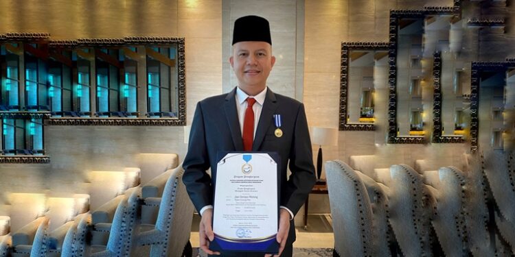 Bupati Gumas, Jaya S Monong menunjukkan penghargaan Manggala Karya Kencana yang diterima dari BKKBN. (Foto : Diskominfosantik Kabupaten Gumas)