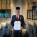 Bupati Gumas, Jaya S Monong menunjukkan penghargaan Manggala Karya Kencana yang diterima dari BKKBN. (Foto : Diskominfosantik Kabupaten Gumas)