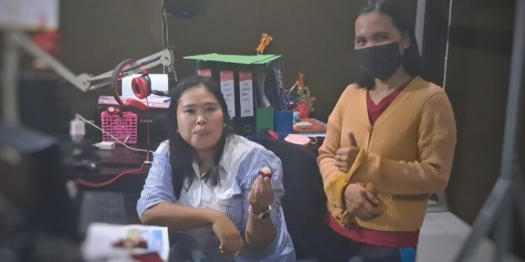 Warga Kuala Kurun Nia (baju putih) langsung mencoba buah tanggaring yang dibelinya dari Trisna Yulianti (kanan), Jumat (29/7/2022). (MASAPNEWS/GCM)