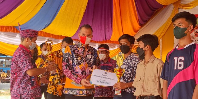 Bupati Gumas Jaya S Monong menyerahkan piala, piagam, dan uang pembinaan kepada para juara lomba, dalam rangka memeriahkan HUT ke-66 SMPN 1 Kurun, di Kuala Kurun, Kamis (18/8/2022). (MASAPNEWS/GCM)