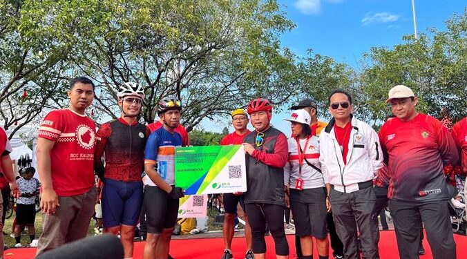 Gubernur Kalimantan Tengah H Sugianto Sabran dan lainnya melakukan penyerahan secara simbolis kartu peserta BPJamsostek kepada 180 Atlet. (Rian Septian)