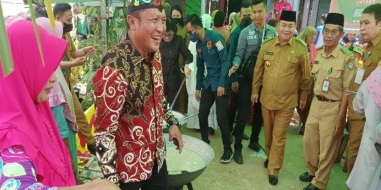 Wakil Ketua Komisi III Dadang Siswanto ikut mengaduk bubur asyura bersama warga di Kelurahan Baamang Hulu Kecamatan Baamang saat Festival Bubur Asyura, Selasa (9/8/2022). (MASAPNEWS/ANT)