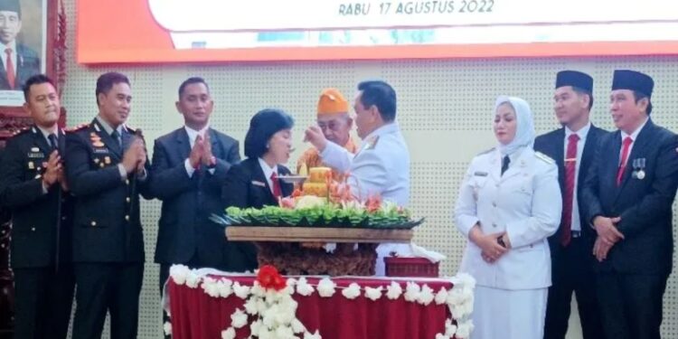 Bupati Halikinnor menyiapkan nasi tumpeng kepada Ketua DPRD Rinie saat syukuran HUT ke-77 Kemerdekaan Republik Indonesia di aula rumah jabatan bupati, Rabu (17/8/2022). (MASAPNEWS/ANT)