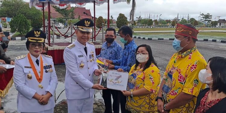 Bupati Gumas Jaya S Monong didampingi Wakil Bupati Efrensia L.P. Umbing menyerahkan penghargaan kepada para pemenang lomba menulis cerita rakyat/legenda, di Kuala Kurun, Rabu (17/8/2022). (MASAPNEWS/GCM)