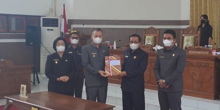 Ketua DPRD Kabupaten Gumas, Akerman Sahidar didampingi Wakil Ketua I Binartha menyerahkan Raperda Perubahan APBD kabupaten 2022 kepada Bupati Jaya S Monong dan Wakil Bupati Efrensia LP Umbing, saat rapat paripurna di Kuala Kurun, Rabu (30/8/2022). (MASAPNEWS/GCM)