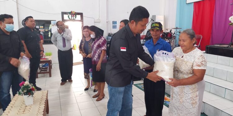 Kasatresnarkoba Gumas Iptu Budi Utomo saat menyerahkan bantuan berupa beras kepada salah satu jemaat yang sedang ibadah di gereja dalam program minggu berkah, Minggu (26/9/2022).(fhoto:Satresnarkoba)