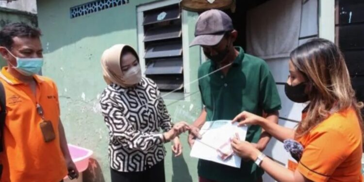 Petugas menyalurkan Bantuan Langsung Tunai (BLT) Bahan Bakar Minyak (BBM) kepada warga di kawasan Pesapen, Surabaya, Jawa Timur, Sabtu (3/9/2022). KPM. (MASAPNEWS/ANT)