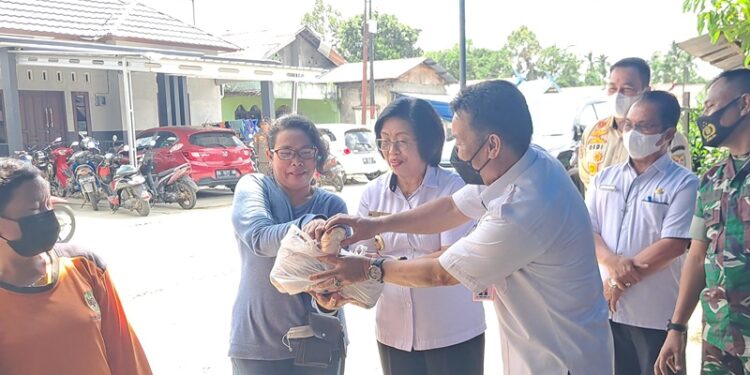 Wakil Bupati Gunung Mas Efrensia LP Umbing didampingi Kepala DPKP Hansli Gonak dan lainnya menjual secara simbolis ikan patin kepada warga, pada pelaksanaan pasar penyeimbang di Kelurahan Tampang Tumbang Anjir, Kecamatan Kurun, Rabu (28/9/2022). (MASAPNEWS/GCM)