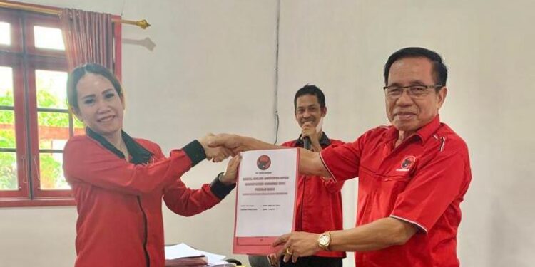 Sekretaris DPC PDI Perjuangan Kabupaten Gumas, Nomi Aprilia (kiri) menyerahkan berkas pendaftaran kepada Ketua DPC PDI Perjuangan Kabupaten Gumas, Akerman Sahidar (kanan), di Kuala Kurun, baru-baru ini. (Foto : PDI Perjuangan Kabupaten Gumas)
