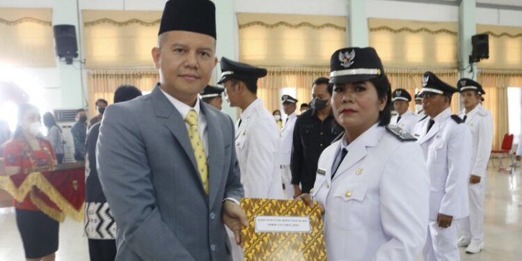 Bupati Gumas Jaya S Monong menyerahkan SK kades kepada salah satu kades perempuan saat pelantikan kades di GPU Damang Batu Kuala Kurun, Jumat (7/10/2022). (Foto : Protokol dan Perjalanan Setda Gumas)