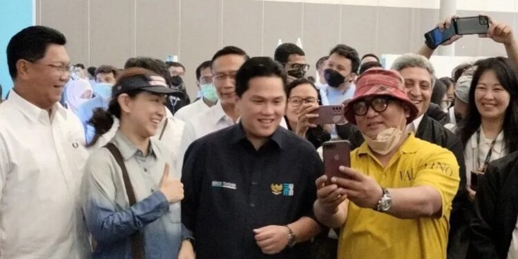Menteri BUMN Erick Thohir (tengah) didampingi Direktur Utama Bank Mandiri Darmawan Junaidi (kiri) berfoto bersama dengan pengunjung dalam pembukaan Garuda Indonesia Travel Fair di ICE BSD, Tangerang pada Jumat (28/10/2022). Erick Thohir mengajak semua pihak untuk membangkitkan pariwisata nasional. (MASAPNEWS/ANT)