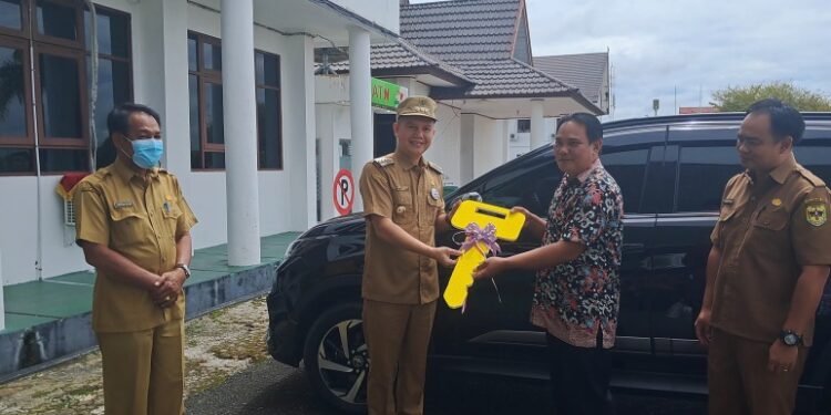 Bupati Gunung Mas Jaya S Monong didampingi Ketua panitia pengadaan mobil operasional GKE Sion Kuala Kurun Untung (kiri) menyerahkan mobil operasional secara simbolis kepada Ketua MPH Jemaat GKE Sion Kuala Kurun Pdt. Asplyn Golvin, M.Th di Kuala Kurun, Selasa (11/10/2022). (MASAPNEWS/GCM)