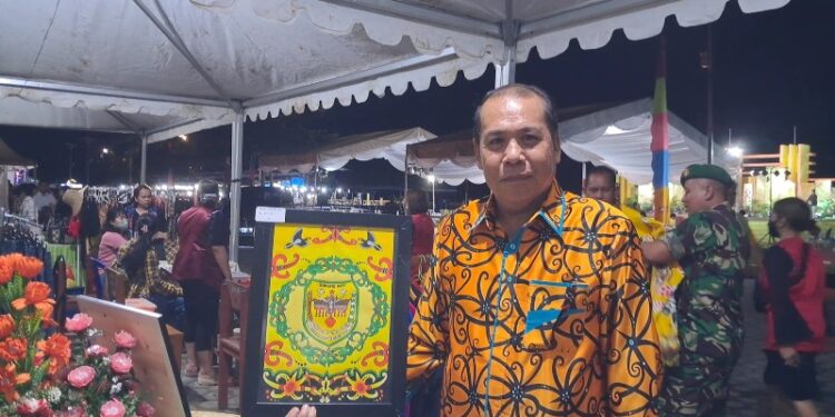 Anggota DPRD Kabupaten Gumas, Punding S Merang menunjukkan salah satu lukisan karya siswa SMPN 1 Kurun. (MASAPNEWS/GCM)