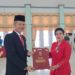 Bupati Gunung Mas, Jaya S Monong (kiri) menyerahkan penghargaan Satyalancana Karya Satya dari Presiden RI kepada salah satu PNS di lingkup pemkab setempat, di Kuala Kurun, Jumat, (28/10/2022). (IST)