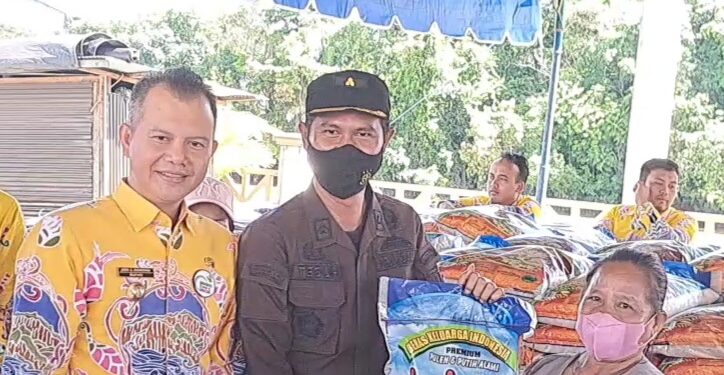 Bupati Gunung Mas Jaya S Monong (kiri) mendampingi Kepala Seksi Intelijen pada Kejaksaan Negeri Gunung Mas, Teguh Iskandar, menyerahkan paket bahan pokok kepada salah satu masyarakat, saat pelaksanaan pasar murah di Taman Kota Kuala Kurun, Kamis (27/10/2022). (MASAPNEWS/GCM)