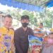 Bupati Gunung Mas Jaya S Monong (kiri) mendampingi Kepala Seksi Intelijen pada Kejaksaan Negeri Gunung Mas, Teguh Iskandar, menyerahkan paket bahan pokok kepada salah satu masyarakat, saat pelaksanaan pasar murah di Taman Kota Kuala Kurun, Kamis (27/10/2022). (MASAPNEWS/GCM)