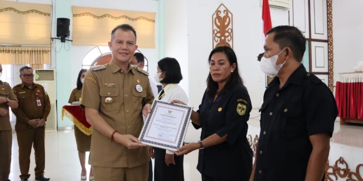 Bupati Gunung Mas, Jaya S Monong menyerahkan piagam penghargaan kepada masyarakat Desa Bereng Malaka, yang diterima secara simbolis oleh BPD Bereng Malaka, di Kuala Kurun, Senin (7/11/2022). (Foto : Diskominfosantik Gumas)