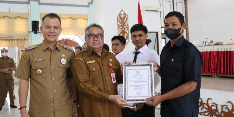 Bupati Gumas Jaya S Monong, mendampingi Kepala DPMD Gumas Yulius, menyerahkan penghargaan kepada desa dengan partisipasi yang tinggi pada pelaksanaan pilkades, di Kuala Kurun, Senin (7/11/2022). (Foto : Diskominfosantik Gumas)