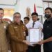 Bupati Gumas Jaya S Monong, mendampingi Kepala DPMD Gumas Yulius, menyerahkan penghargaan kepada desa dengan partisipasi yang tinggi pada pelaksanaan pilkades, di Kuala Kurun, Senin (7/11/2022). (Foto : Diskominfosantik Gumas)