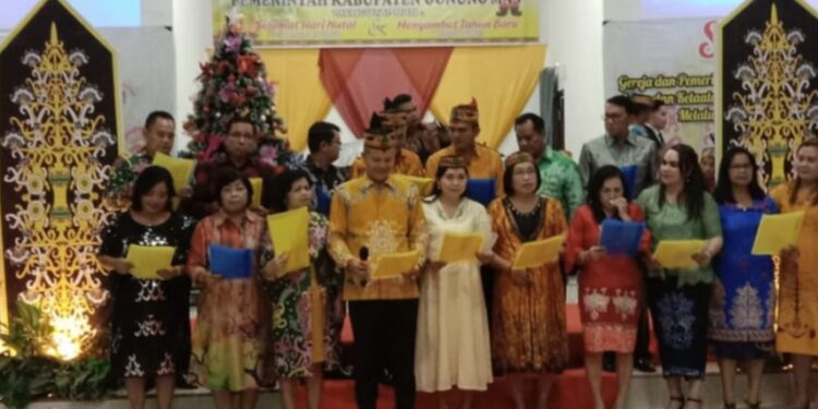 Bupati Gumas Jaya Samaya Monong dan istri Mimie Mariatie Jaya S Monong, Wabup Efrensia LP Umbing dan lainnya, menyampaikan puji-pujian saat Safari Natal Kecamatan Manuhing, Minggu (11/12/2022). (Foto : Diskominfosantik Gumas)