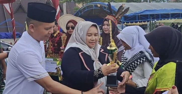 Legislator Kabupaten Gunung Mas, Siti Hilmiah didampingi Bupati, Jaya S Monong menyerahkan piala kepada para pemenang Pawai Tarhib Ramadhan 1444 H di Taman Kota Kuala Kurun, Sabtu (18/3/2023). (IST)
